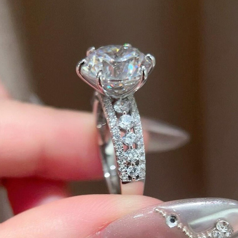 Moissanite Engagement Ring 1 Carat - 4カラットの輝きを放つ、クラシックな六本爪デザインのモアッサナイトと高炭素ダイヤモンドを使用した、透かし模様が施された女性用リング。素材は925スターリングシルバー。